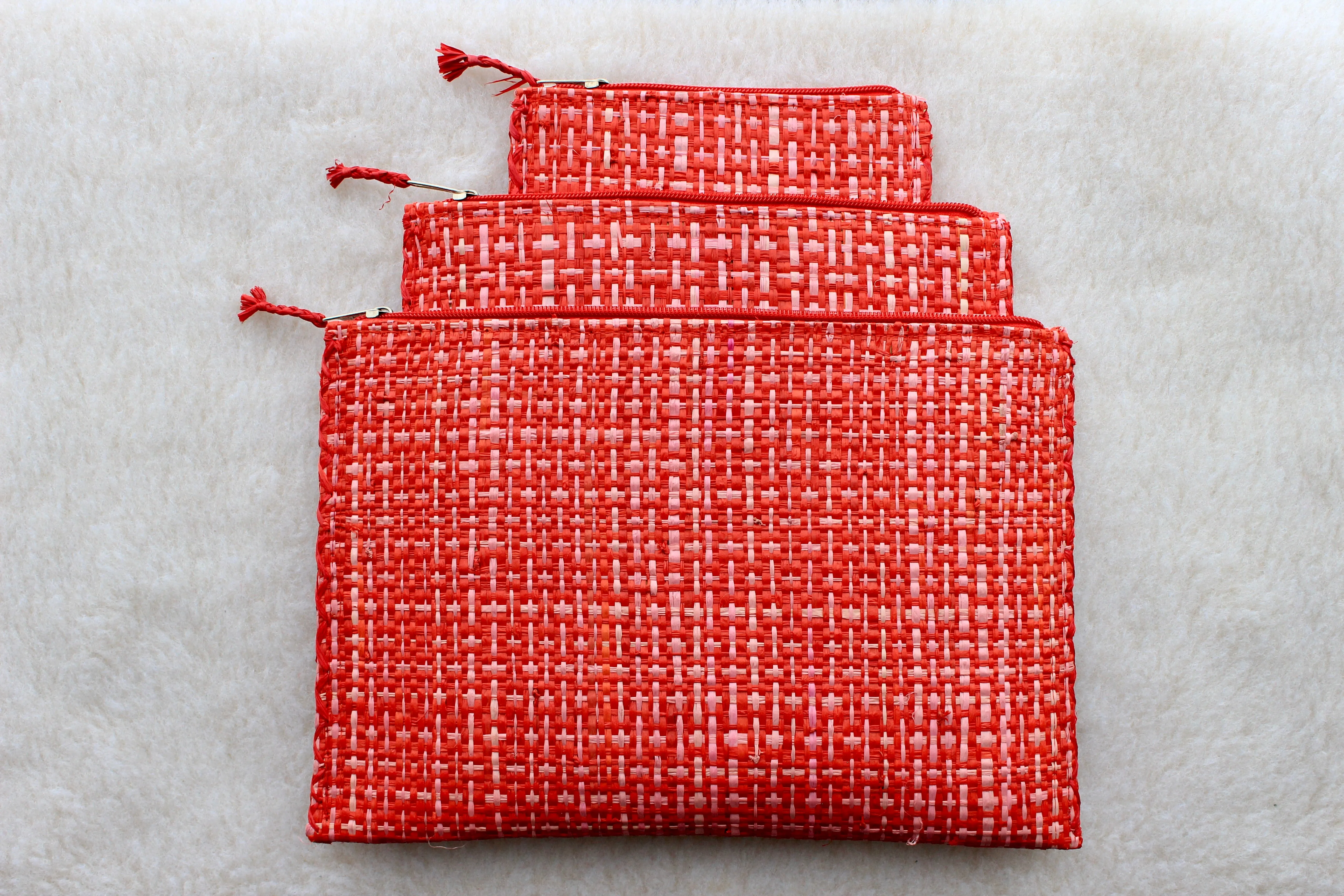 set of 3 hot pink and red raffia woven clutches with leather trim